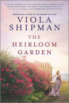Image of The Heirloom Garden Book cover, shows a woman walking along a large flowering shrub.